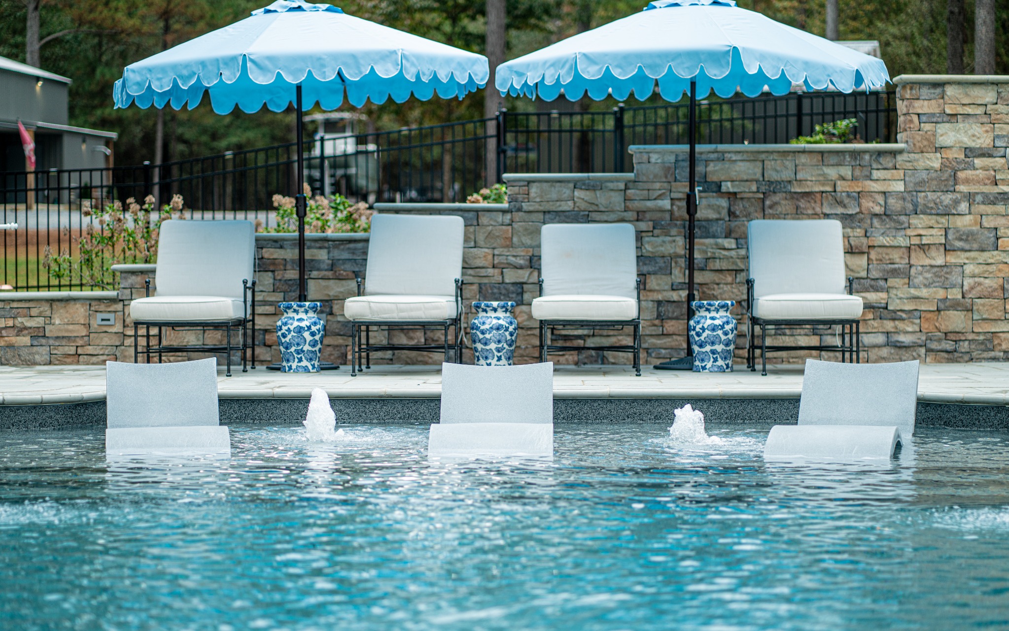 Completed residential pool with clear blue water and landscaped patio